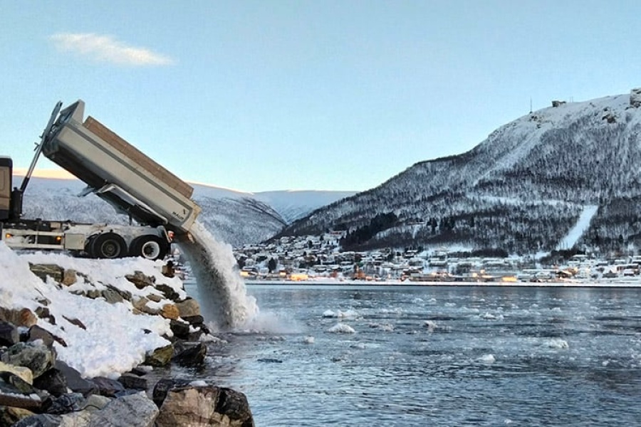 En lastebil tømmer snø i sundet i Tromsø