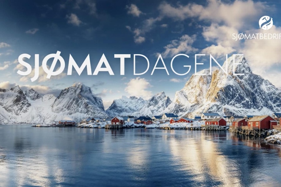 Reklamebanner for Sjømatdagene, med stor hvit tekst «SJØMATDAGENE» over et panoramisk vinterbilde av nordnorsk landskap: snødekte fjell, tradisjonelle røde rorbuer langs fjorden og en rolig vannflate under en blå himmel. I øvre høyre hjørne står navnet «SJØMATBEDRIFTENE» med en liten fiskelogo.