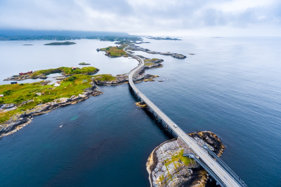 Luftfoto av Atlanterhavsveien som slynger seg over små øyer og broer langs kysten av Møre og Romsdal.