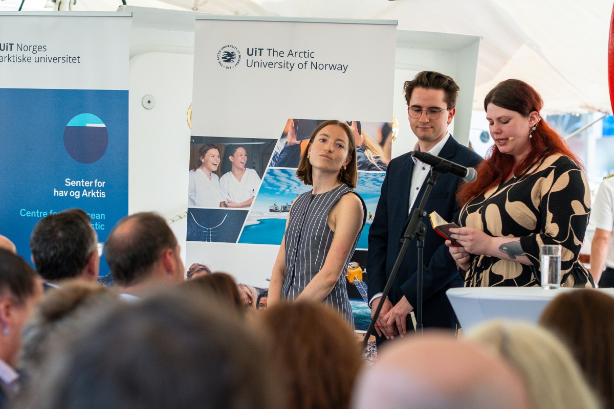 Tre deltakere står på scenen og holder innlegg under et arrangement i regi av UiT Norges arktiske universitet og Senter for hav og Arktis, mens publikum følger med.