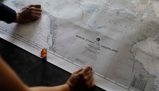 To personer holder et kart over Arktis med tittelen ‘Bering Strait to Greenland’.