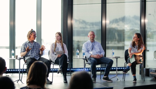 Fire personer sitter i panel under en konferanse, i samtale om grønn omstilling i fiskerinæringen.