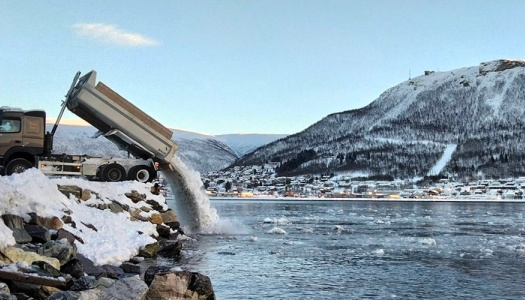En lastebil tømmer snø i sundet i Tromsø