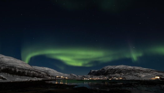 Grønt nordlys på mørk himmel