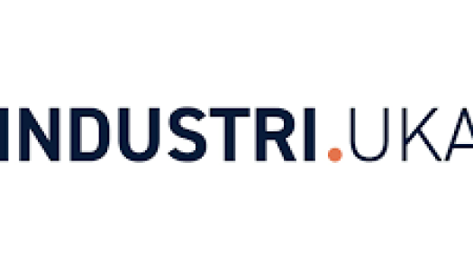 Logo med ordet «INDUSTRI» i mørkeblått, etterfulgt av en liten oransje prikk og ordet «UKA» i lysere grått, på hvit bakgrunn.