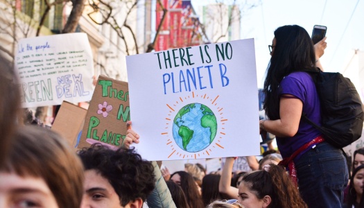 En folkemengde under en klimademonstrasjon. En person holder opp et skilt med teksten «There is no Planet B» og en tegning av jordkloden.