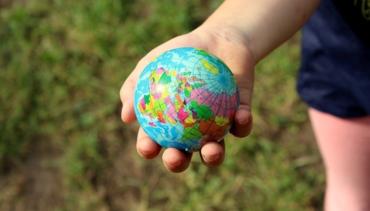 En barnehånd holder en liten jordklode.