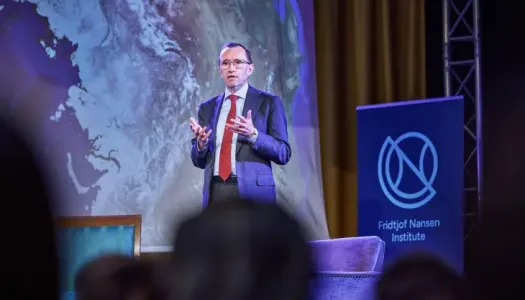 Mann står på scenen å snakker. 