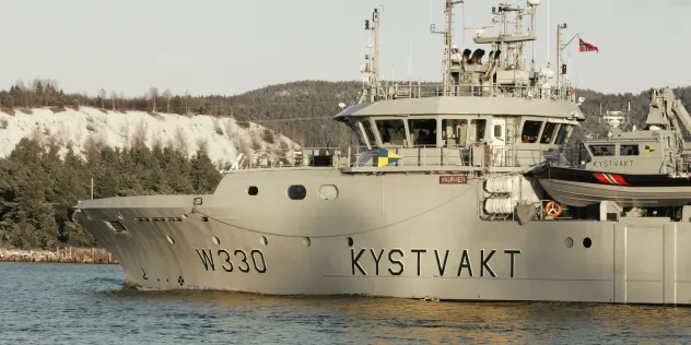 Norsk kystvaktfartøy (W330) på sjøen nær kysten.