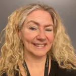 Portrett av smilende kvinne med blondt hår. 