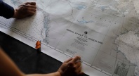 To personer holder et kart over Arktis med tittelen ‘Bering Strait to Greenland’.