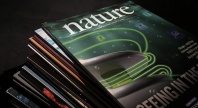 Stabel med tidsskriftet Nature, med forsiden av øverste utgave synlig i grønn- og svarttoner.