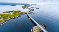 Luftfoto av Atlanterhavsveien som slynger seg over små øyer og broer langs kysten av Møre og Romsdal.