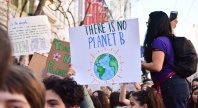 En folkemengde under en klimademonstrasjon. En person holder opp et skilt med teksten «There is no Planet B» og en tegning av jordkloden.